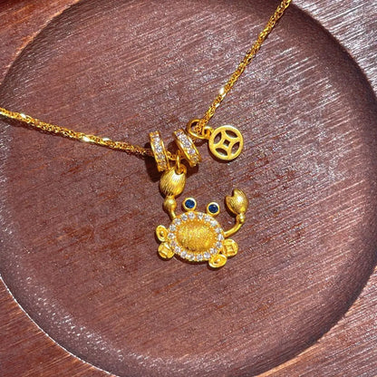 Gold-Plated Crab Pendant Necklace on wood