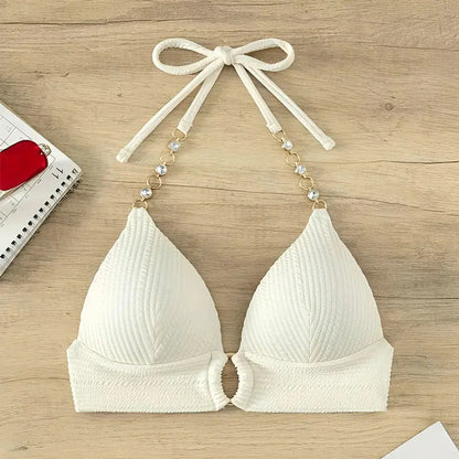 White bikini top with bow straps on a wooden surface