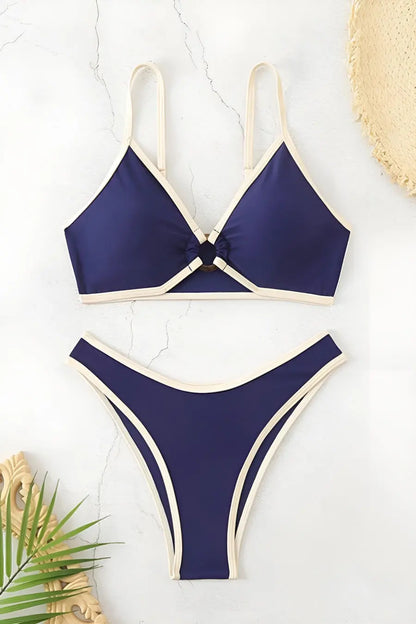 Navy blue bikini set on a light background with decorative elements.